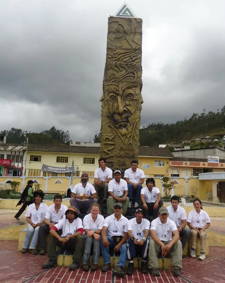 The Montañas Sagradas team photographed together in a town square in front of a monument